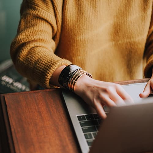 Job seeker typing on a laptop, representing candidate testimonials.